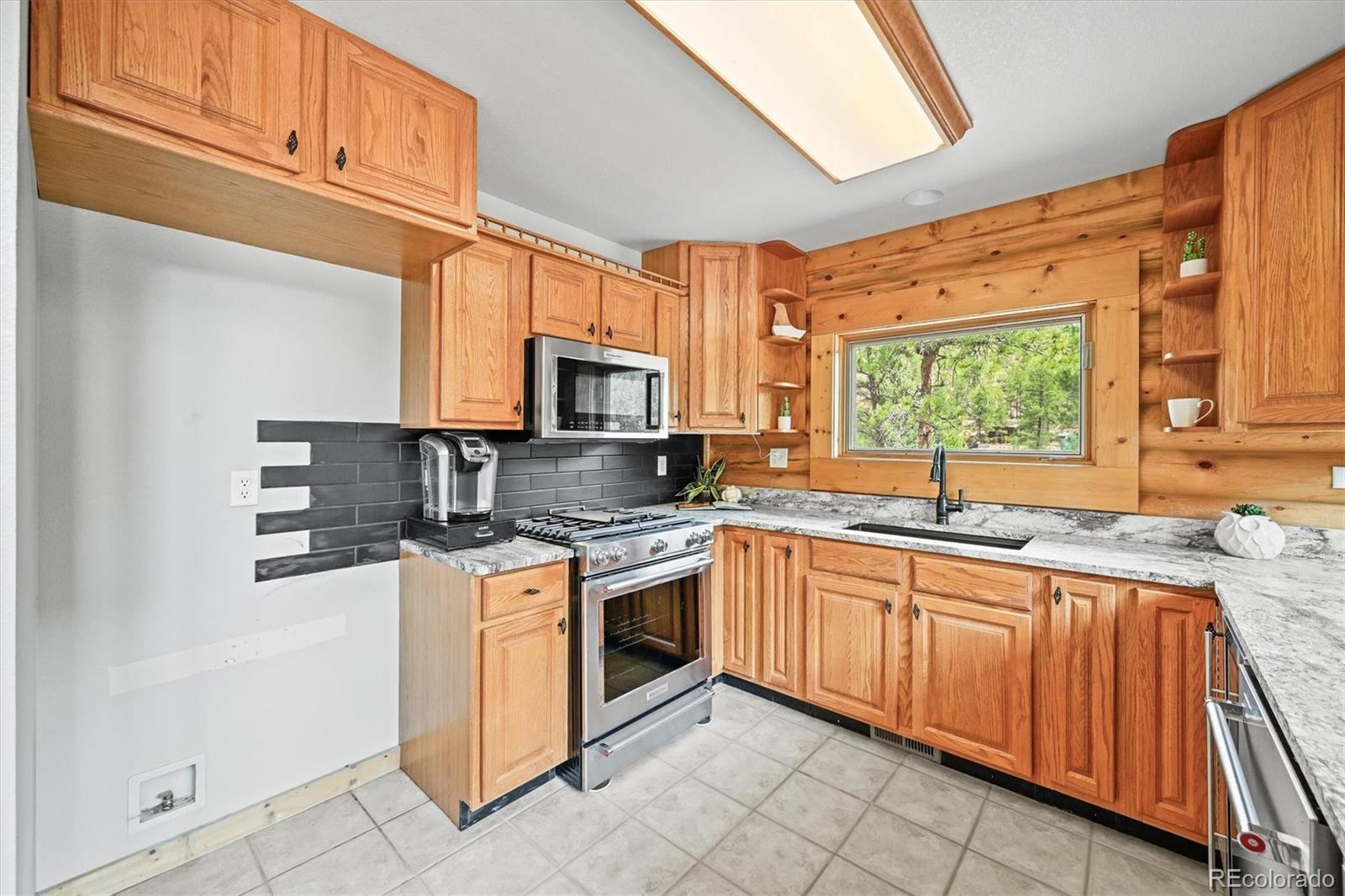 9868 South Overlook Road Sedalia, CO 80135 - Photo 28 of 50 a kitchen with stainless steel appliances granite countertop a stove sink and microwave