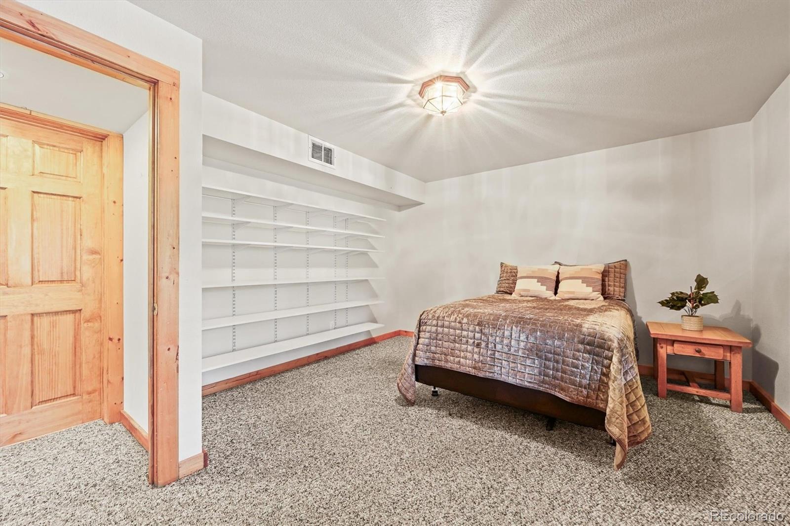 9868 South Overlook Road Sedalia, CO 80135 - Photo 48 of 50 a bedroom with a bed and a chandelier