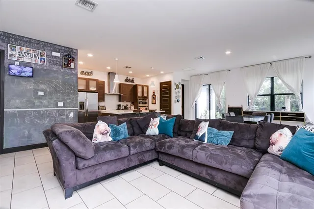 a living room with a couch and a view of kitchen