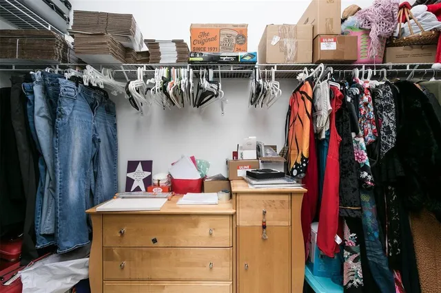 a view of walk in closet with clothes and shoes