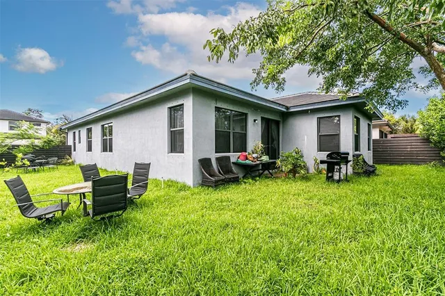 a backyard of a house with table and chairs
