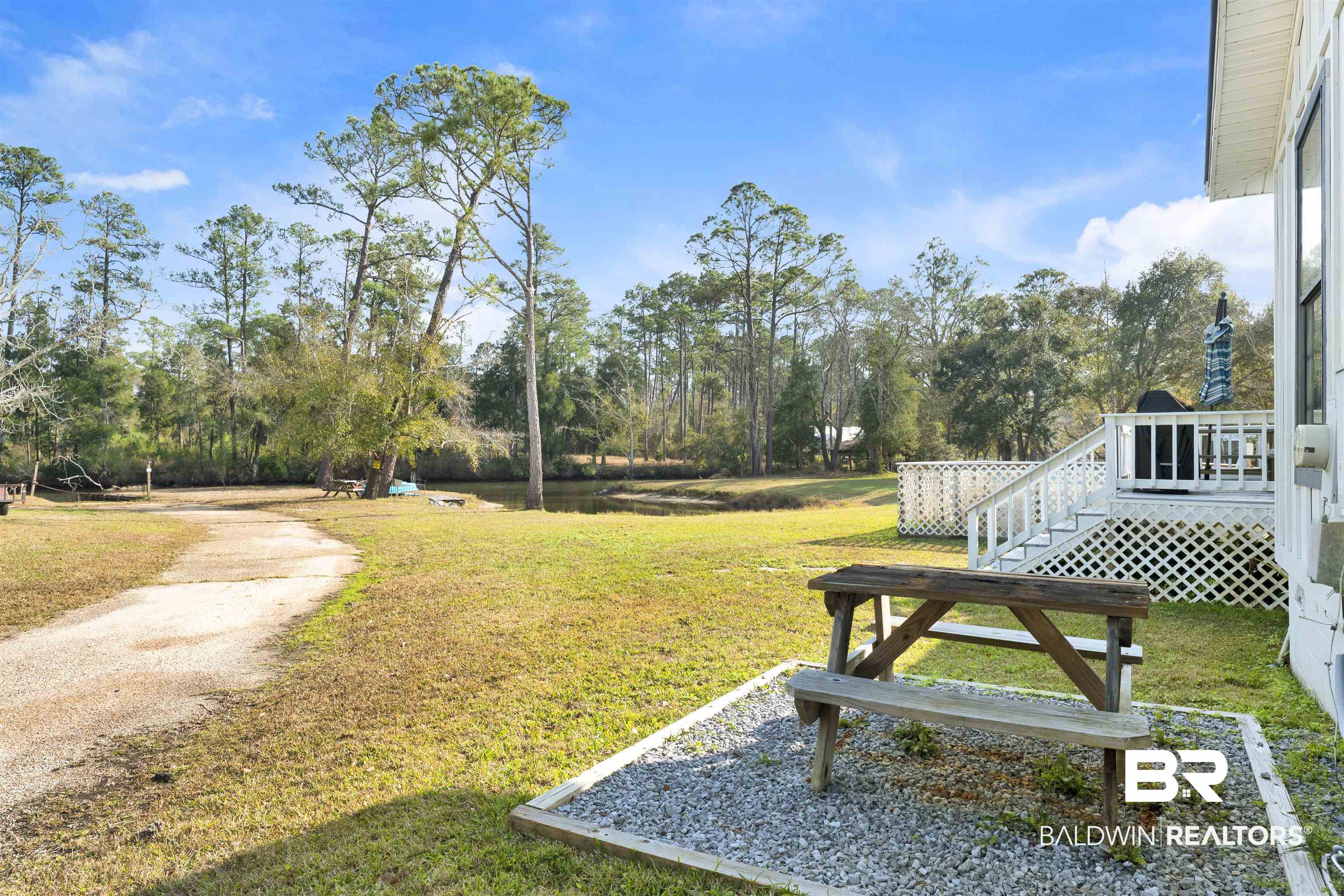23770 Miflin Road Elberta, AL 36530 - Photo 20 of 38 View of grassy yard with view of scattered trees and a deck with water view