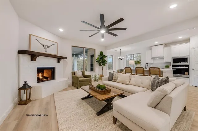 a living room with furniture a fireplace and a ceiling fan