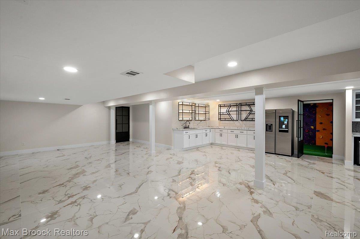 4597 Clarkston Road Clarkston, MI 48348 - Photo 53 of 74 Spacious open-concept area featuring large format floor tiling, recessed lighting, a built-in wet bar with white cabinetry, and stainless steel appliances