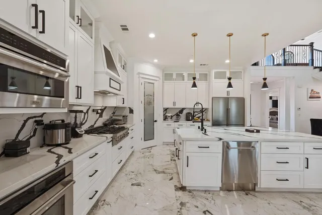 a kitchen with stainless steel appliances granite countertop a sink and a refrigerator