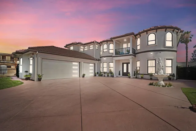 a front view of a house with yard and tress