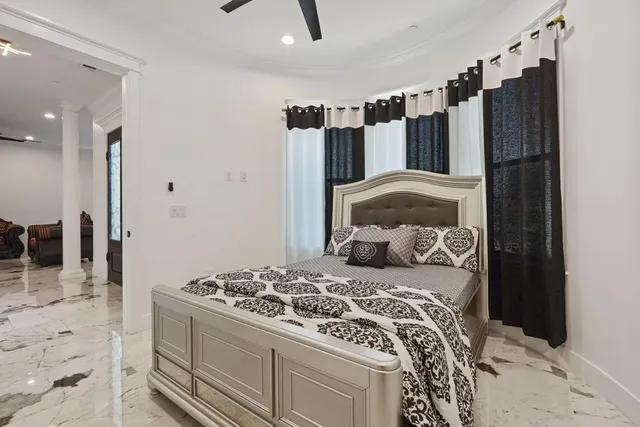 a living room with furniture ceiling fan and a large window