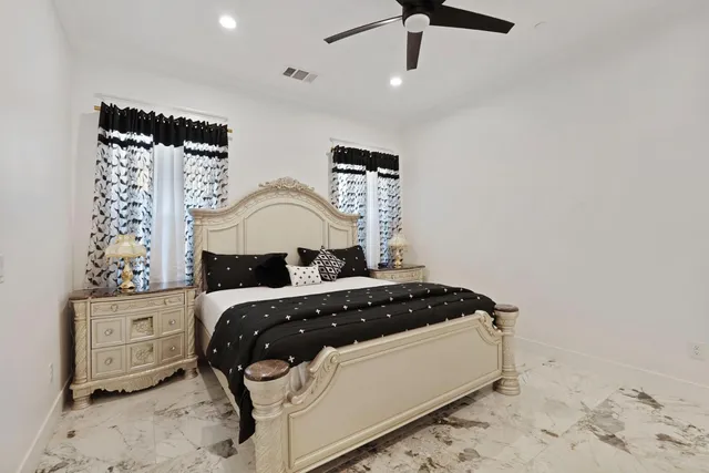 a bedroom with a bed and ceiling fan