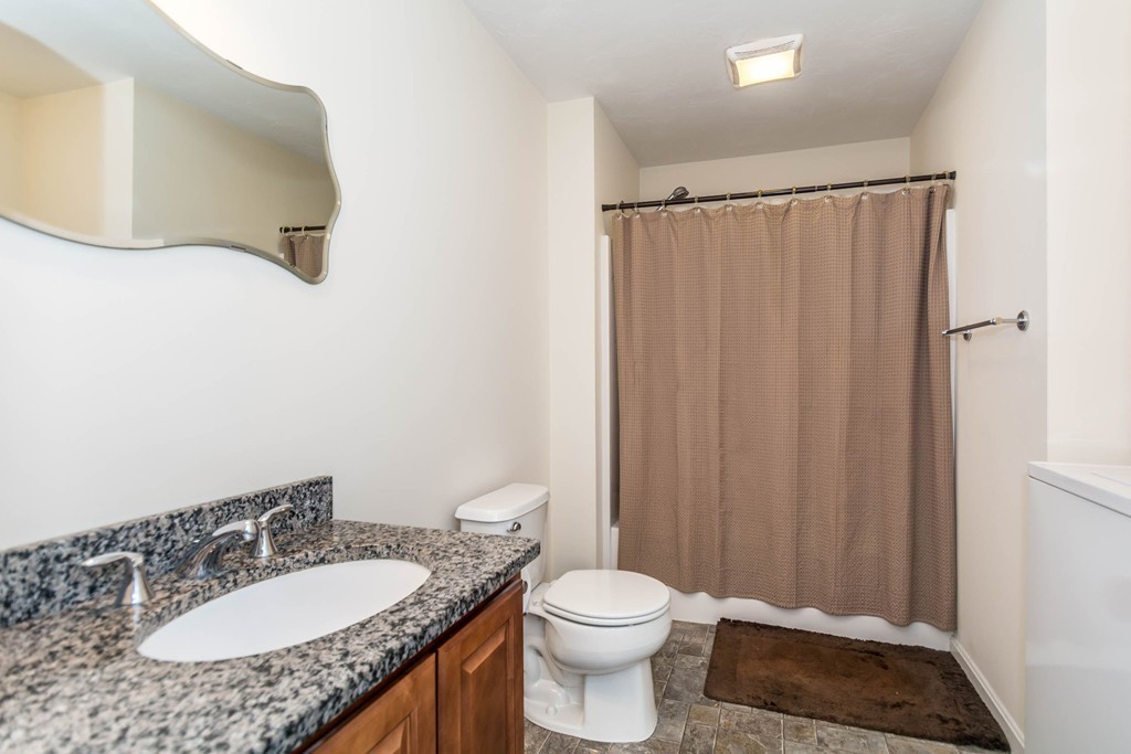 41 Boston Road, Unit 124 Billerica, MA 01862 - Photo 14 of 18 a bathroom with a granite countertop sink and a mirror