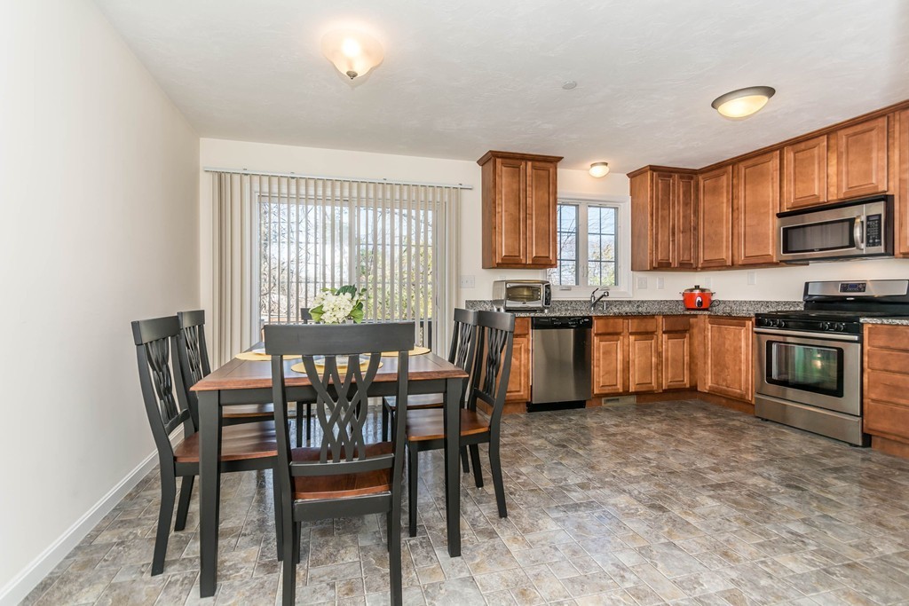 41 Boston Road, Unit 124 Billerica, MA 01862 - Photo 8 of 18 a kitchen with a table chairs sink and cabinets