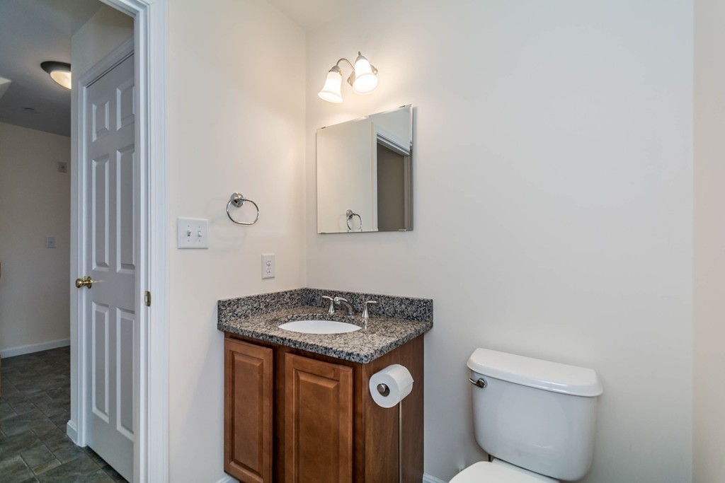41 Boston Road, Unit 124 Billerica, MA 01862 - Photo 9 of 18 a bathroom with a granite countertop toilet and a sink