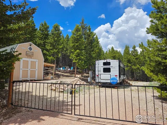 a view of a brick wall with a small yard and a wooden fence