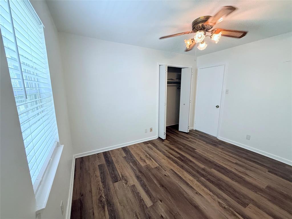 160 Bob White Road Denison, TX 75020 - Photo 22 of 29 Room featuring wood-finish flooring, a window with blinds, a ceiling fan with integrated lighting, and a closet with bifold doors