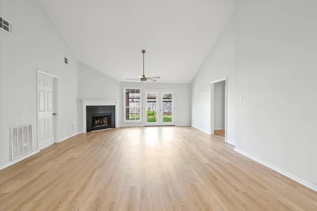 an empty room with windows and fan