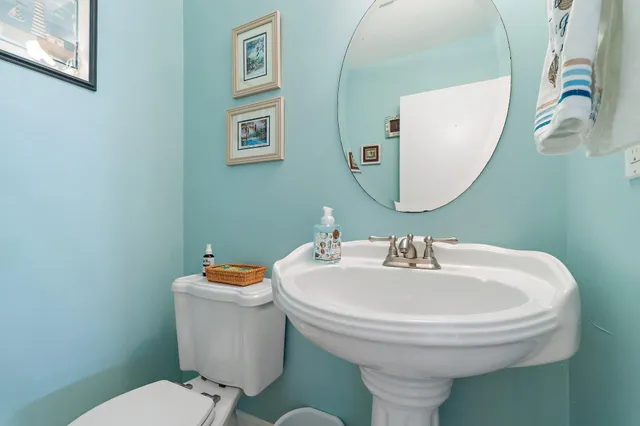 a bathroom with a sink a toilet and mirror