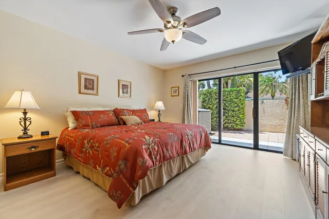 a spacious bedroom with a balcony a bed and a chandelier