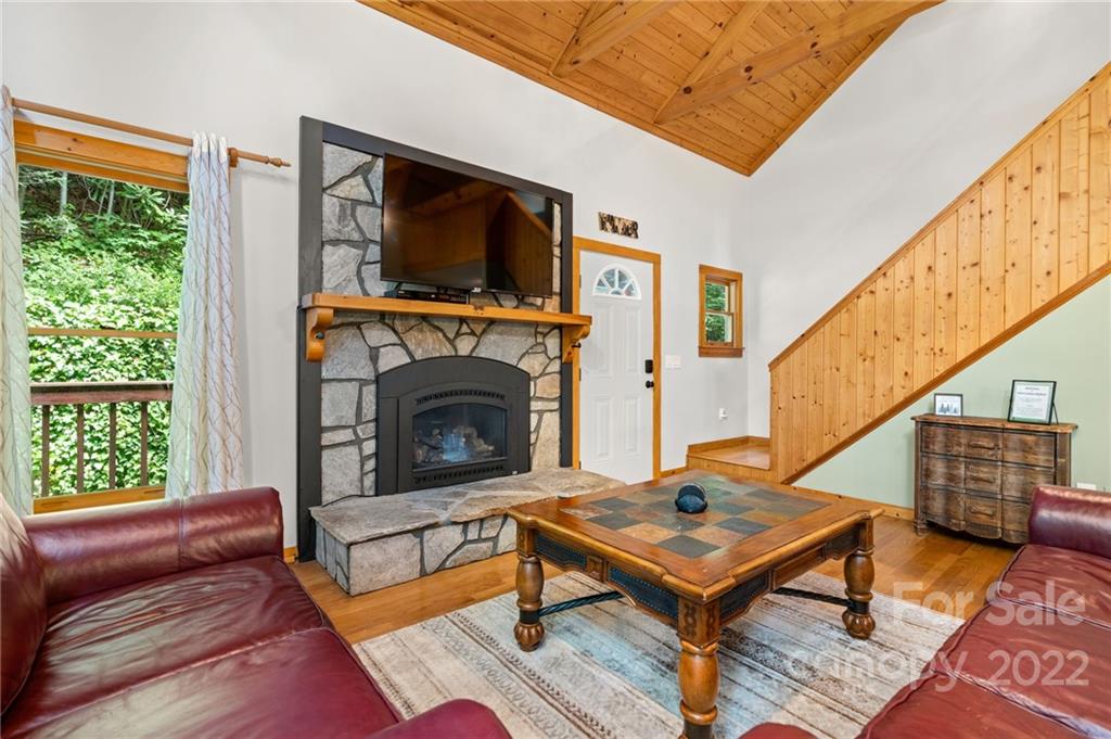 7 Twin Mountain View Road Canton, NC 28716 - Photo 11 of 36 a living room with furniture a flat screen tv and a fireplace