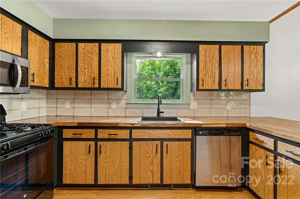7 Twin Mountain View Road Canton, NC 28716 - Photo 18 of 36 a kitchen with stainless steel appliances granite countertop a stove a sink and a microwave