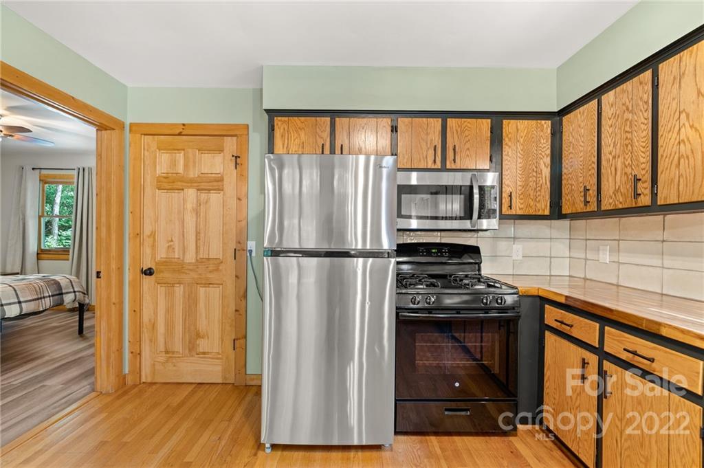 7 Twin Mountain View Road Canton, NC 28716 - Photo 20 of 36 a kitchen with stainless steel appliances granite countertop a refrigerator and a stove top oven