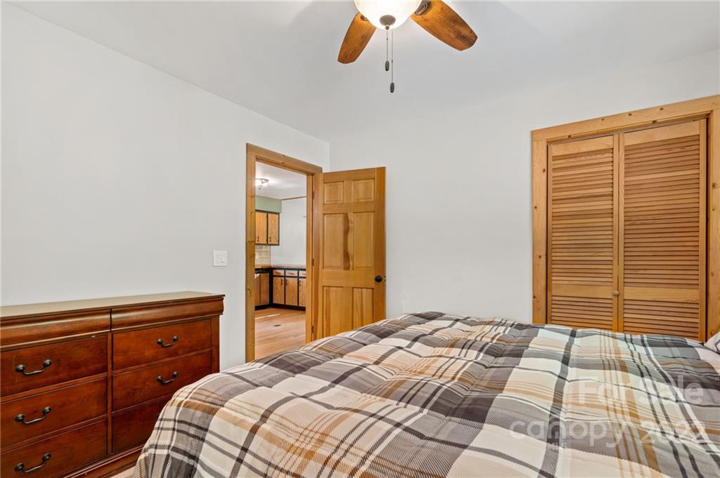 7 Twin Mountain View Road Canton, NC 28716 - Photo 25 of 36 a bedroom with a large bed and a chandelier