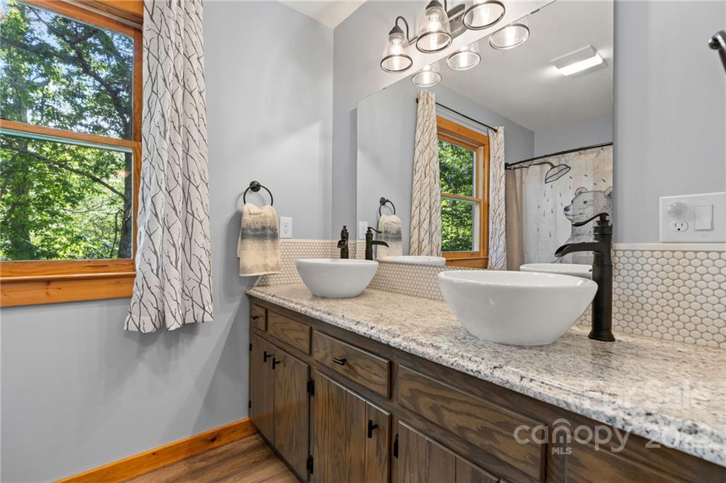 7 Twin Mountain View Road Canton, NC 28716 - Photo 32 of 36 a spacious bathroom with a granite countertop sink mirror and window