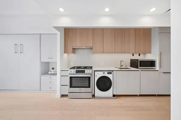 a kitchen with white cabinets and white appliances