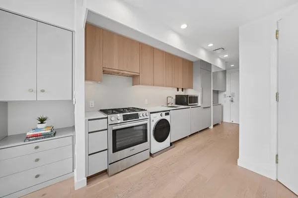 a kitchen with kitchen island stainless steel appliances a stove a sink and a refrigerator