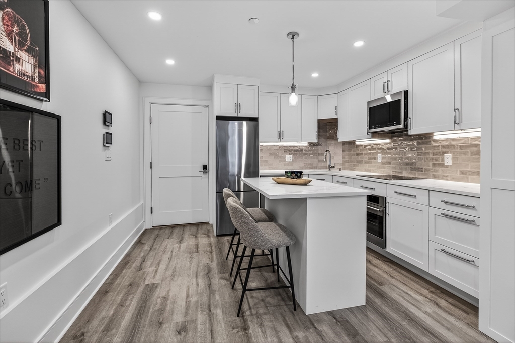 149 Charles Street, Unit 4 Boston, MA 02114 - Photo 6 of 11 a kitchen with a refrigerator a sink and cabinets