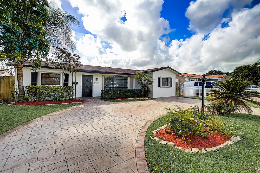 a front view of a house with a garden