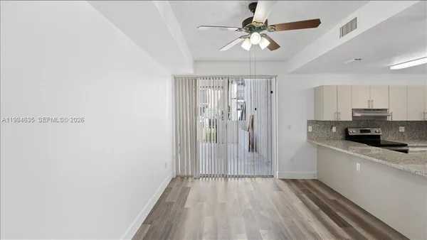 a kitchen with stainless steel appliances a refrigerator a sink dishwasher a stove and white countertops with wooden floor