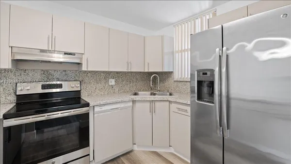 a kitchen with cabinets appliances and a counter space