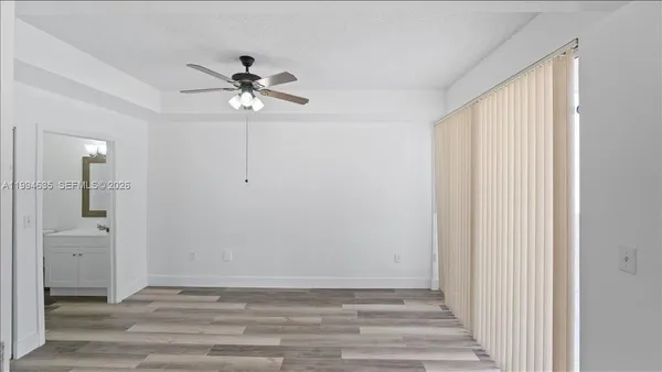 a view of a livingroom with wooden floor and a ceiling fan