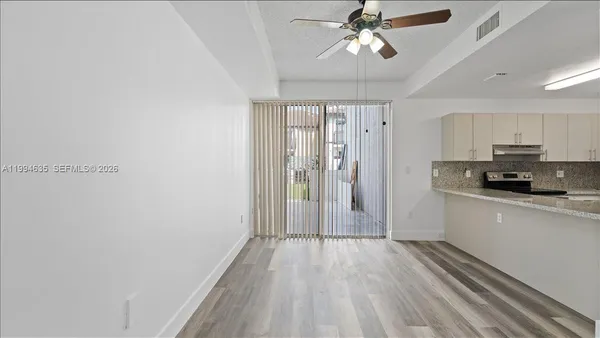 a view of a kitchen with a sink and dishwasher a refrigerator with wooden floor