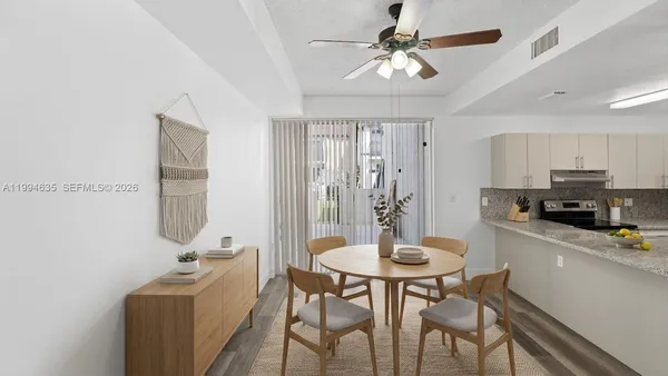 a kitchen with stainless steel appliances kitchen island granite countertop a dining table and chairs