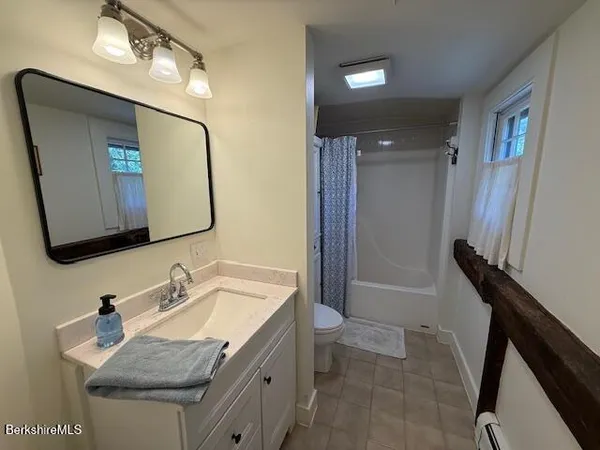 a bathroom with a granite countertop sink a mirror and a bathtub