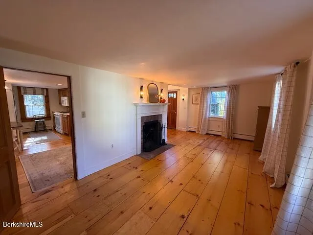 a view of a livingroom with wooden floor and a fireplace