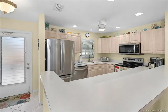 a kitchen with stainless steel appliances a refrigerator sink and microwave