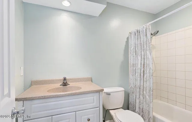 a bathroom with a sink toilet vanity and tub