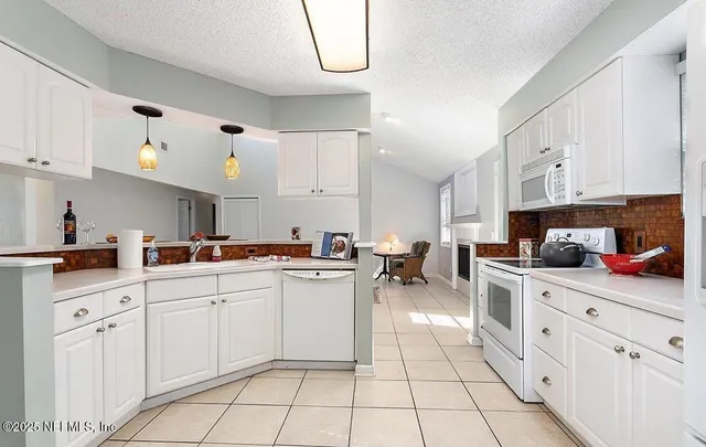 a kitchen with cabinets and chairs