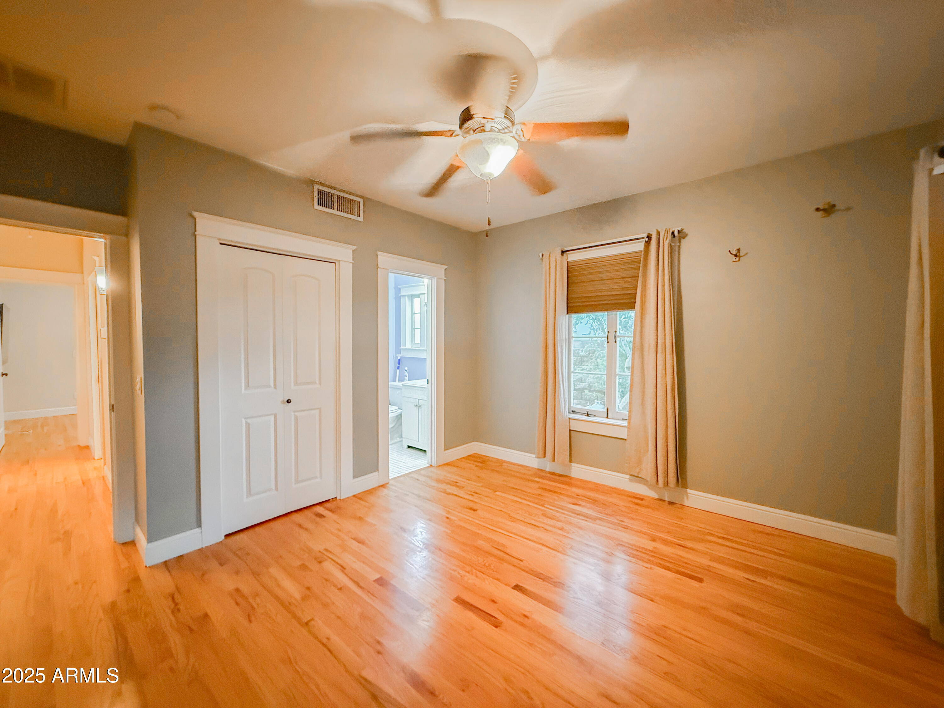 56 East Vernon Avenue Phoenix, AZ 85004 - Photo 17 of 29 a view of an empty room with wooden floor and a window