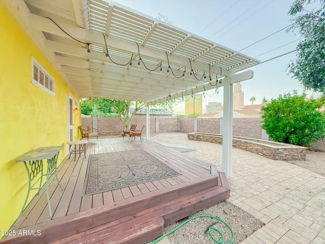 a view of a patio with table and chairs with wooden floor and plants
