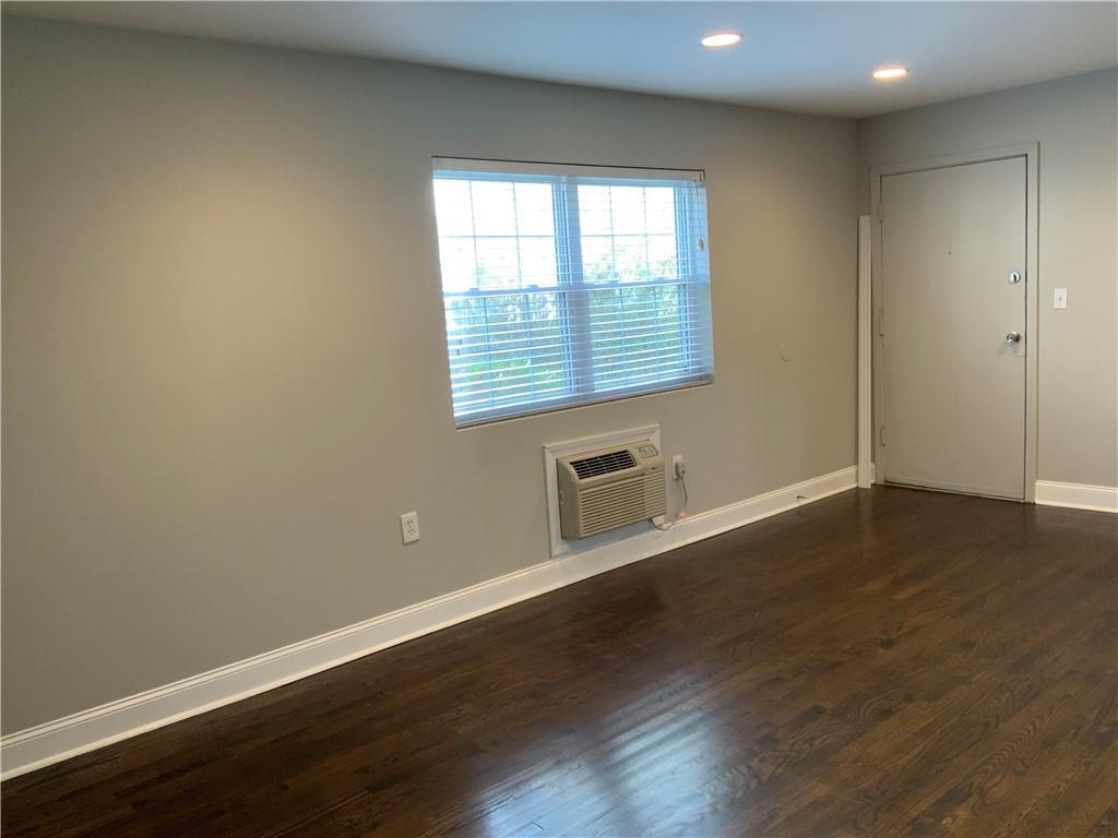 805 Piedmont Avenue Northeast, Unit 5 Atlanta, GA 30308 - Photo 2 of 12 an empty room with wooden floor and windows