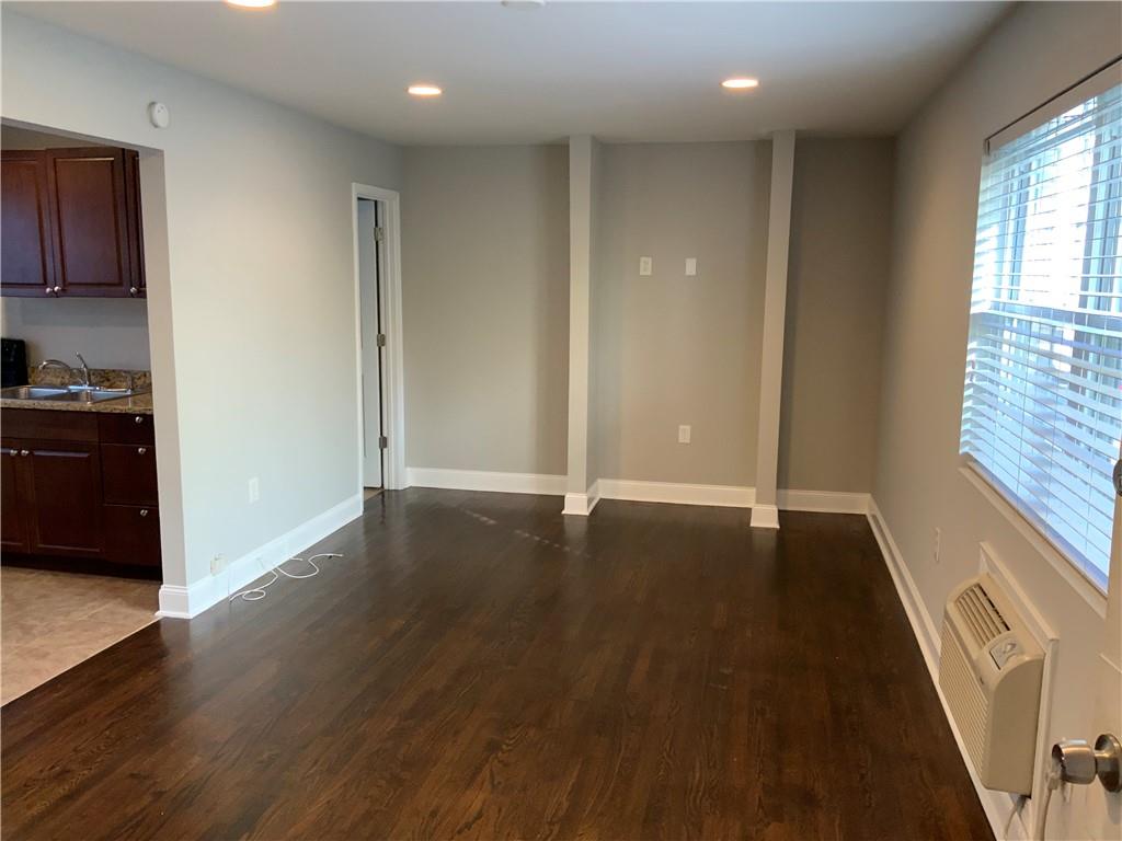 805 Piedmont Avenue Northeast, Unit 5 Atlanta, GA 30308 - Photo 3 of 12 a view of an empty room with wooden floor and a window