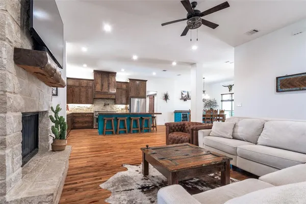 a living room with furniture kitchen view and a fireplace