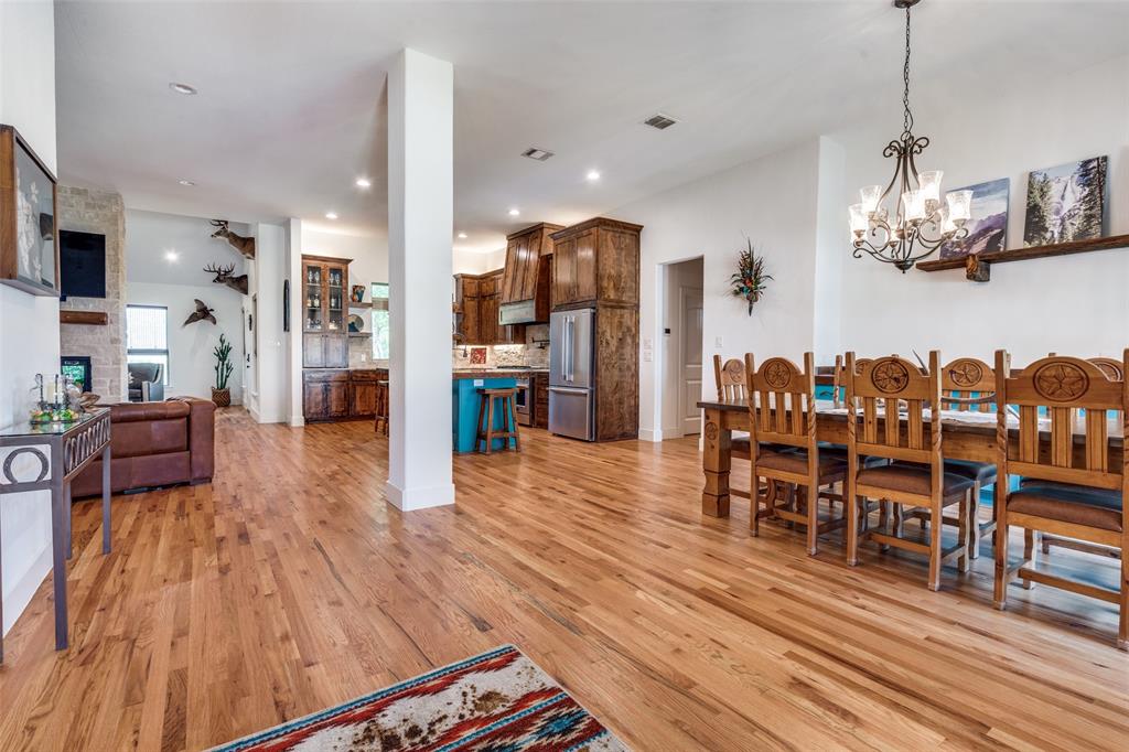 626 Lone Tree Road Nevada, TX 75173 - Photo 15 of 40 a view of a dining room and livingroom with furniture wooden floor a chandelier