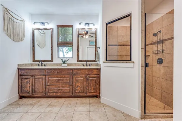 a bathroom with a granite countertop sink a mirror and a shower