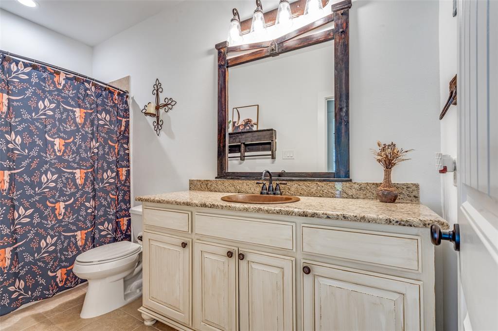 626 Lone Tree Road Nevada, TX 75173 - Photo 20 of 40 a bathroom with a granite countertop sink vanity mirror and toilet