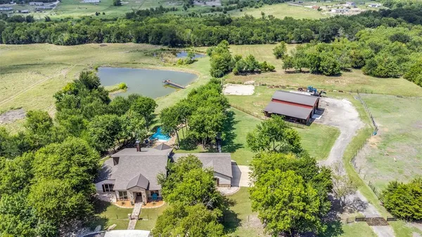 an aerial view of a house with pool garden and outdoor seating