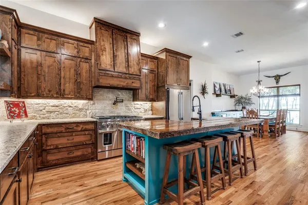 a kitchen with stainless steel appliances granite countertop a stove refrigerator and cabinets