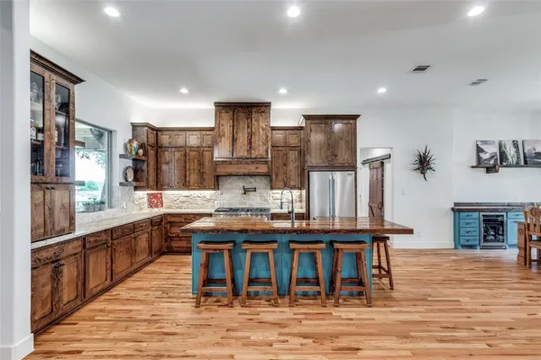 a kitchen with stainless steel appliances kitchen island granite countertop a table and chairs in it